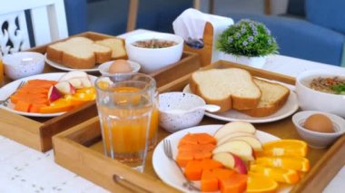 Otelde basit bir kahvaltı. Basit bir restoranda her zamanki kahvaltı. Taze yiyecek, yumurta, tost, yulaf lapası, portakal suyu ve meyveli tepsi. Kafede Asya usulü sağlıklı yemek.