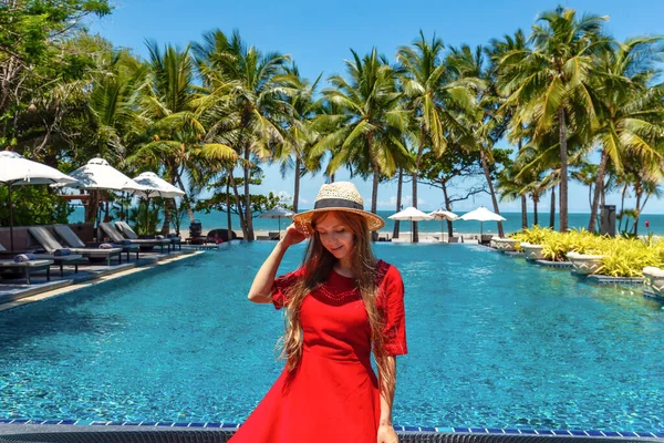 여행하는 여행하는 여자는 근처의 휴양지 수영장 근처에서 휴가를 즐기고 모자를 — 스톡 사진