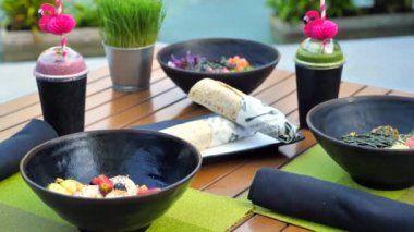 Vejetaryen sandviç dürümü ve açık hava moda kafede tam buğdaydan yapılmış müsrif ekmek. Vejetaryen dondurması, smoothie ile bardaklar ve sağlıklı öğle yemeğinde taze çiğ balık ile pirinç kasesi..