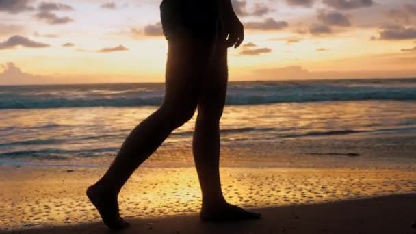 Молодая Женщина Босиком Ходит Пляжу Золотом Закате Оставляя Следы Песке — стоковое видео