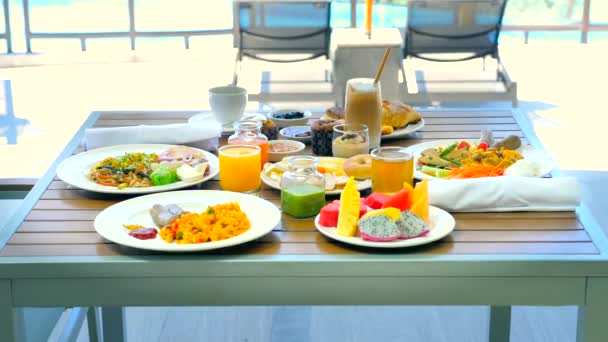 海の景色を望むトロピカルホテルでの朝食 現代的なリゾートのレストランでビュッフェ料理 旅行と夏休みの概念 — ストック動画