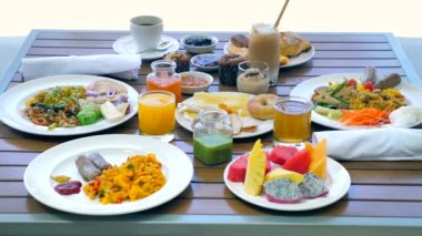 Ahşap masada organik yiyecek ve içeceklerle otel yemeği ya da kahvaltı. Yemek ve tatil konsepti - tatil ve tropikal tatiller. Kahvaltı servisi..