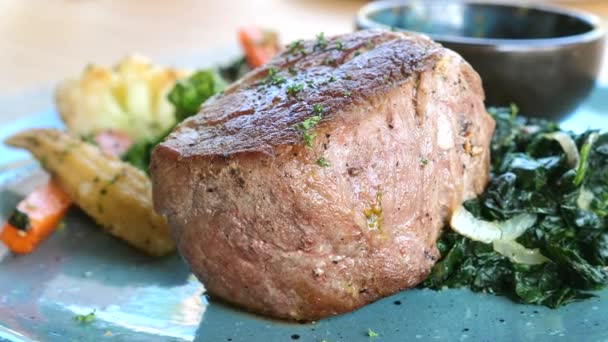 用菠菜和烤蔬菜在盘子里把新鲜牛肉牛排包好 餐厅提供新鲜烤好的牛排或软骨素肉 在咖啡店享用美味午餐 — 图库视频影像