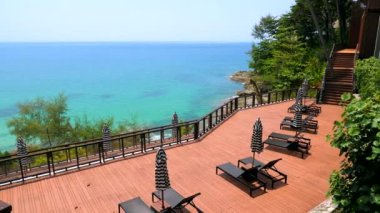 Modern tatil beldesinde yaz tatili. Lüks oteldeki turkuaz deniz manzaralı şemsiyeli boş güneş salonları. Tayland, Phuket, Asya 'da tatil kavramı.