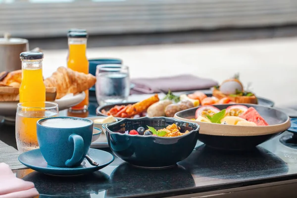 Lüks otelde kahvaltı servisi yapmış. Çeşitli sağlıklı yiyeceklerle dolu havuz başı masası taze sıkılmış meyve suları, yumurta, meyve ve meyve suyu kasesi. Modern tatil köyünde yüzme havuzunun önünde sabah büfesi..