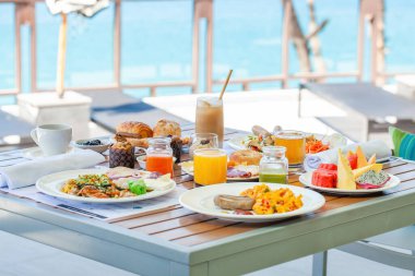 Tropik otellerde deniz manzaralı kahvaltı. Modern tatil köyündeki restoranda açık büfe yemekleri. Seyahat ve yaz tatili kavramı.