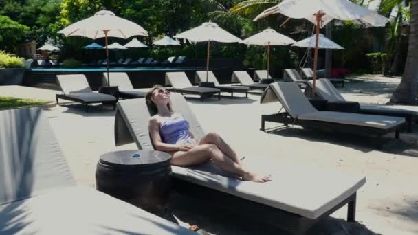 Młoda Seksowna Kobieta Stroju Kąpielowym Okularach Odpoczywająca Samotnie Leżaku Plaży — Wideo stockowe