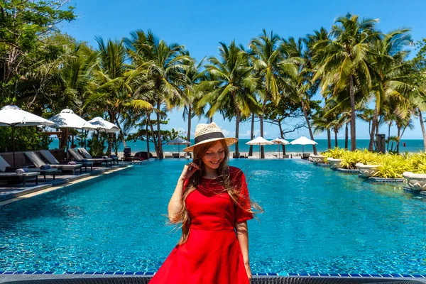 여행하는 여행하는 여자는 근처의 휴양지 수영장 근처에서 휴가를 즐기고 모자를 — 스톡 사진