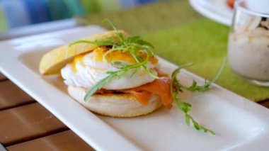 Healthy protein breakfast with delicious eggs, salad and cereal porridge. Served food in cafe. Eating eggs Benedict on lunch. Dinner in luxury hotel