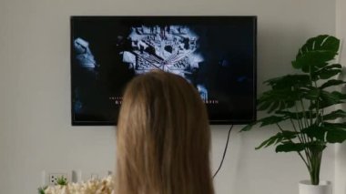 Tanımlanamayan bir kadın evde dinleniyor ve TV 'de Dragon HBO TV dizisini izliyor ve patlamış mısır yiyor. Game of Thrones 'un ön bölümü. Phuket, Tayland - Eylül, 2022
