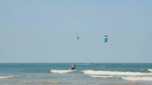 Kite boarding. Kitesurfing freestyle at hot sunny day. Active extreme water sport. Kite surfing or windsurfing on blue sea water.