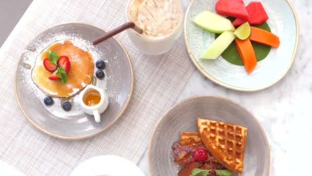 팬케이크 과일로 맛있는 식사를 호텔에서 식사하는 카페에서 페이스트리 카푸치노와 식사를 — 비디오