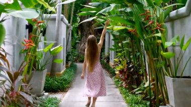 Tropik yeşilliklerin arasında gezen, doğanın tadını çıkaran, yeşil yapraklara dokunan, tatilde dinlenen bir kadın. Tayland, Phuket 'te Asya' da tatil yapan bir bayan turist. Yaz egzotik seyahat beldesi