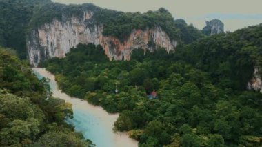 Sahilde manzara ve mavi su gölü, orman ve kayalarla güzel bir manzara. Egzotik adaya seyahat turu. Tayland, Hong Adası 'na tekne gezisi. Asya turizmi, tatil, tatil