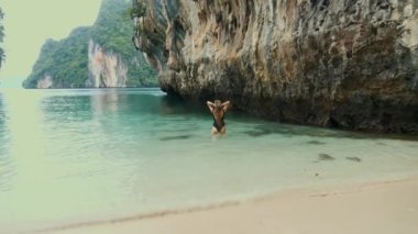 Seyahat eden kadınlar turkuaz suda dinlenir, güzel doğanın tadını çıkarırlar. Kireçtaşı kayaları, Tayland, Hong Adası 'nda turkuaz su. Egzotik turistik gezintiye çıkmış bir kadın yolcu.