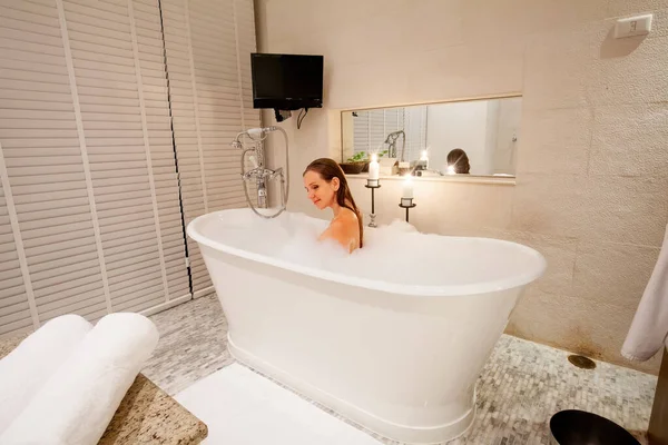 年轻的性感女人在充满泡沫的泡泡中在浴室里放松一下 在豪华酒店或家里装上浴缸 洗洗你的头 保健的概念 — 图库照片