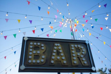 Renkli flamalar ve direkte ampuller olan bar afişi. Açık hava partisi geçmişi