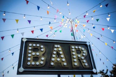 Renkli flamalar ve direkte ampuller olan bar afişi. Açık hava partisi geçmişi