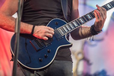 Hard rock müzisyenleri sahne alıyor. Gitarist