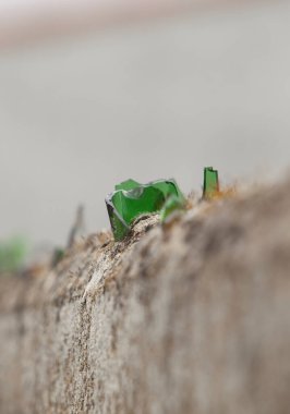 Duvarın üstü kırık camlarla kaplı. Keskin parçalar havana işlenmiş. 