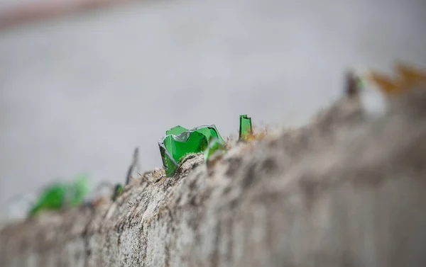 壁の上に壊れたガラスで覆われた 迫撃砲に象眼された鋭い破片 — ストック写真