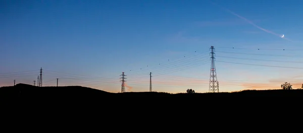 高压电塔在黄昏的天空中的作用 全景拍摄 — 图库照片