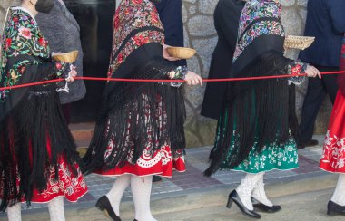 Caceres, İspanya - 20 Ocak 2022: Tören kordonunu tutarken konfeti ve anason topu taşıyan Regaoras. Carantonas Acehuche Festivali, Caceres, İspanya. 