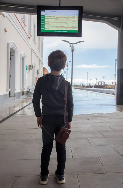 鉄道駅の子供の男の子の出発監視を探している 子供のコンセプトで電車の中で旅行 — ストック写真