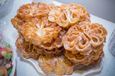 Geleneksel kavrulmuş florlar ya da çiçeklerle dolu bir tabak. İspanyol böreği şekerle kaplanmış.