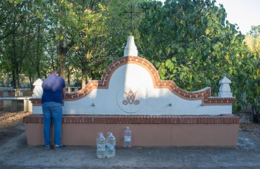 La Codosera, Spain - August 21th, 2021: Sanctuary of Our Lady of Chandavila. Local man filling bottles at holy fountain 
