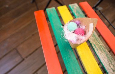 Cornets filled with colorful balls and feathers. Outdoor wedding background