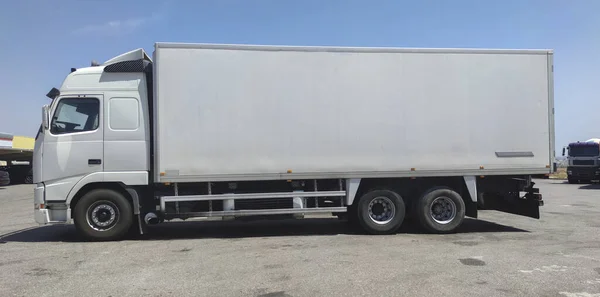 Semi-trailer truck parked at trucks service area. White box