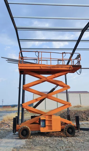 Mobile aerial work platform building industrial unit beams. Professional mounter scissor lift