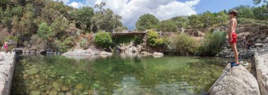 Child boy at La Maquina Natural swimming pool. Crystal-clear waters spot in the heart of La Vera County,  Caceres, Extremadura, Spain