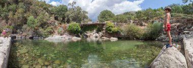 Child boy at La Maquina Natural swimming pool. Crystal-clear waters spot in the heart of La Vera County,  Caceres, Extremadura, Spain