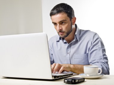 dizüstü bilgisayarda çalışan sakallı genç adam