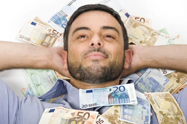 Glücklicher junger Mann liegt auf Geldscheinen — Stockfoto