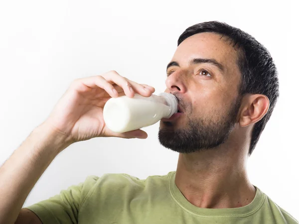 Junger schöner Mann mit Bart trinkt Milch — Stockfoto