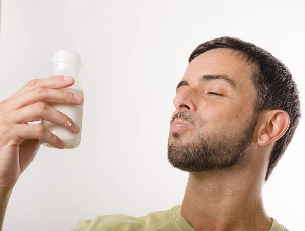 Joven hombre guapo con barba bebiendo leche — Foto de Stock