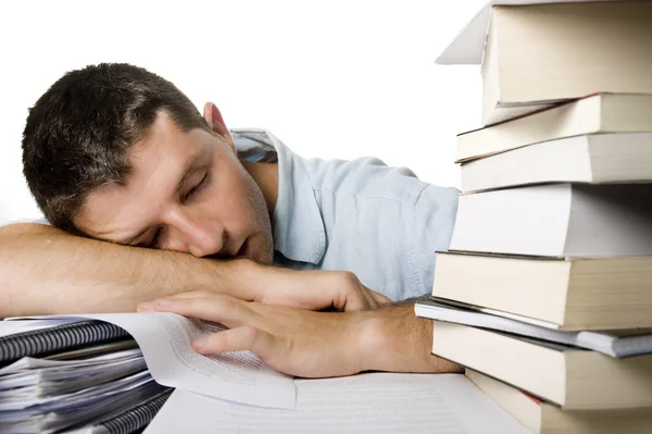 Mladý muž přemohlo spaní nad hromadou knih — Stock fotografie