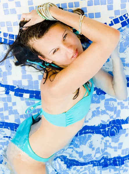 Mujer salpicando agua en la playa — Foto de Stock