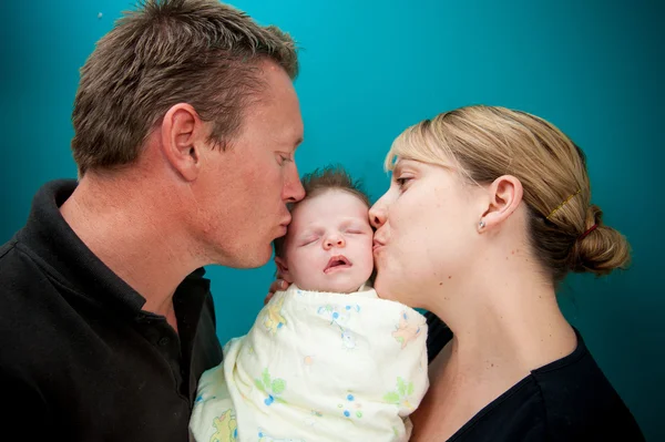 Padre e madre baciare il loro bambino — Foto Stock