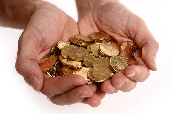 Mannen händerna fulla av mynt — Stockfoto