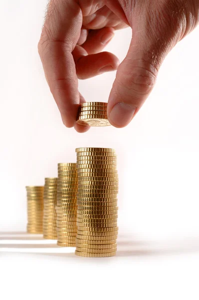 Male hand picking Euro Coins piled in stacks — Stock Photo, Image