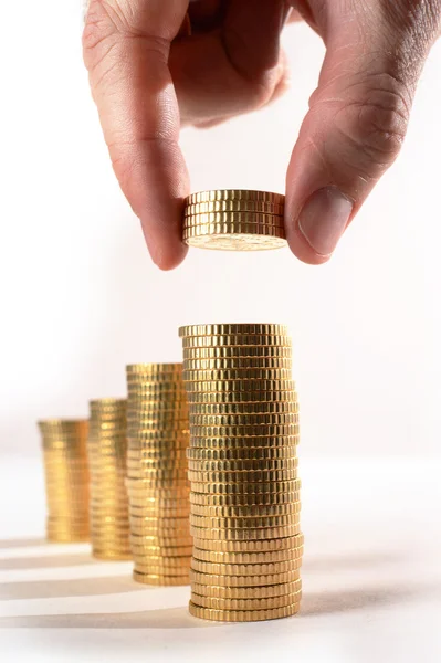 Male hand picking Euro Coins piled in stacks — Stock Photo, Image