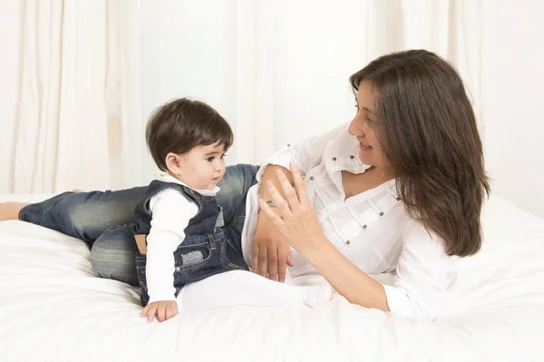 Mother and daughter playing on bed isolated — Stock Photo, Image