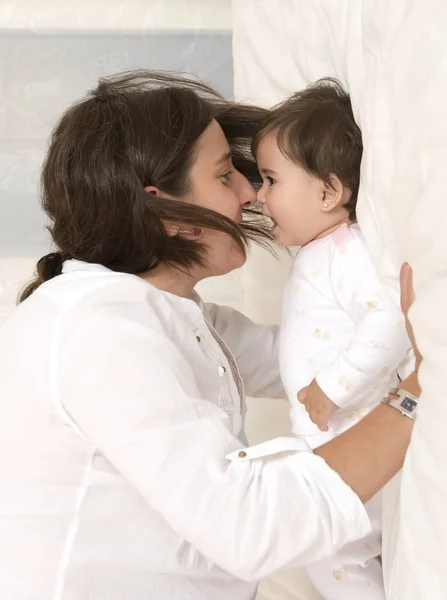 Mãe e filha brincando na cama isolados — Fotografia de Stock