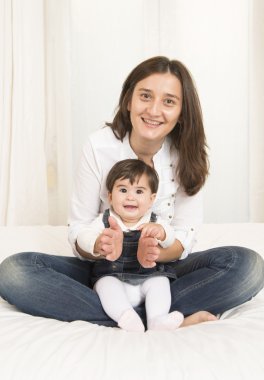 Anne ve kızı yatağa oynama