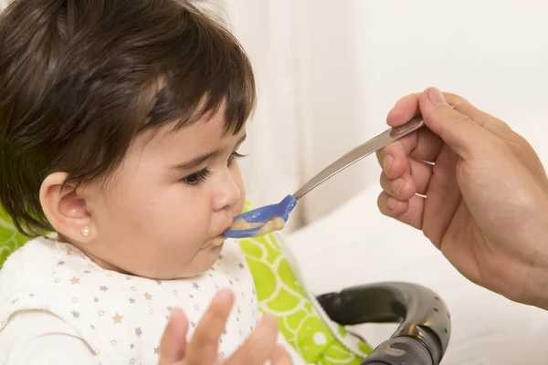 Bir kız sevimli sevimli bebek besleme — Stok fotoğraf