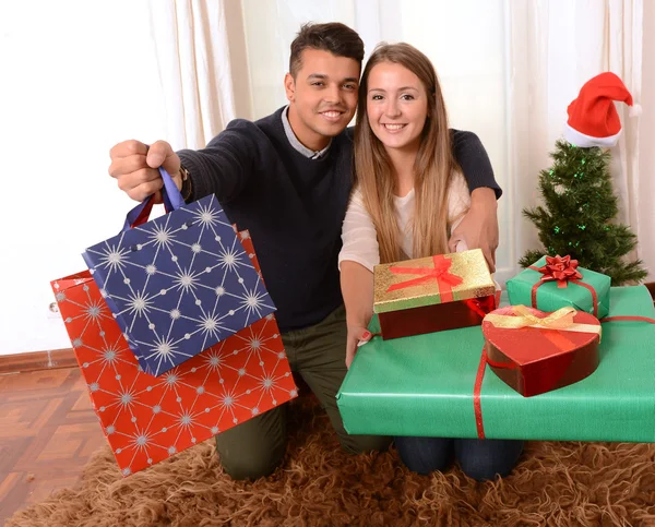 Jovem casal feliz segurando presentes de Natal — Fotografia de Stock